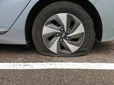 Yol kenarında havası tamamen inmiş otomobil lastiği